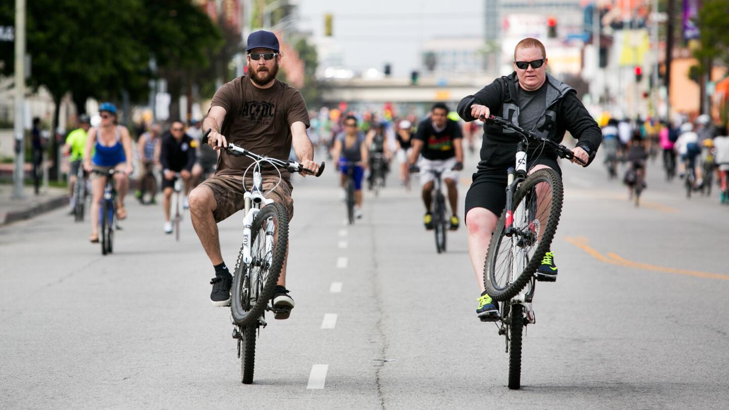 Riders perform wheelies as they ride down Lankershim Blvd. during CicLAvia.