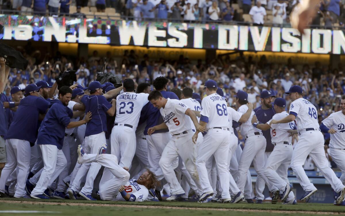 The Dodgers celebrate after winning the National League West division with a 4-3 walk-off victory over the Rockies on Sept. 25.