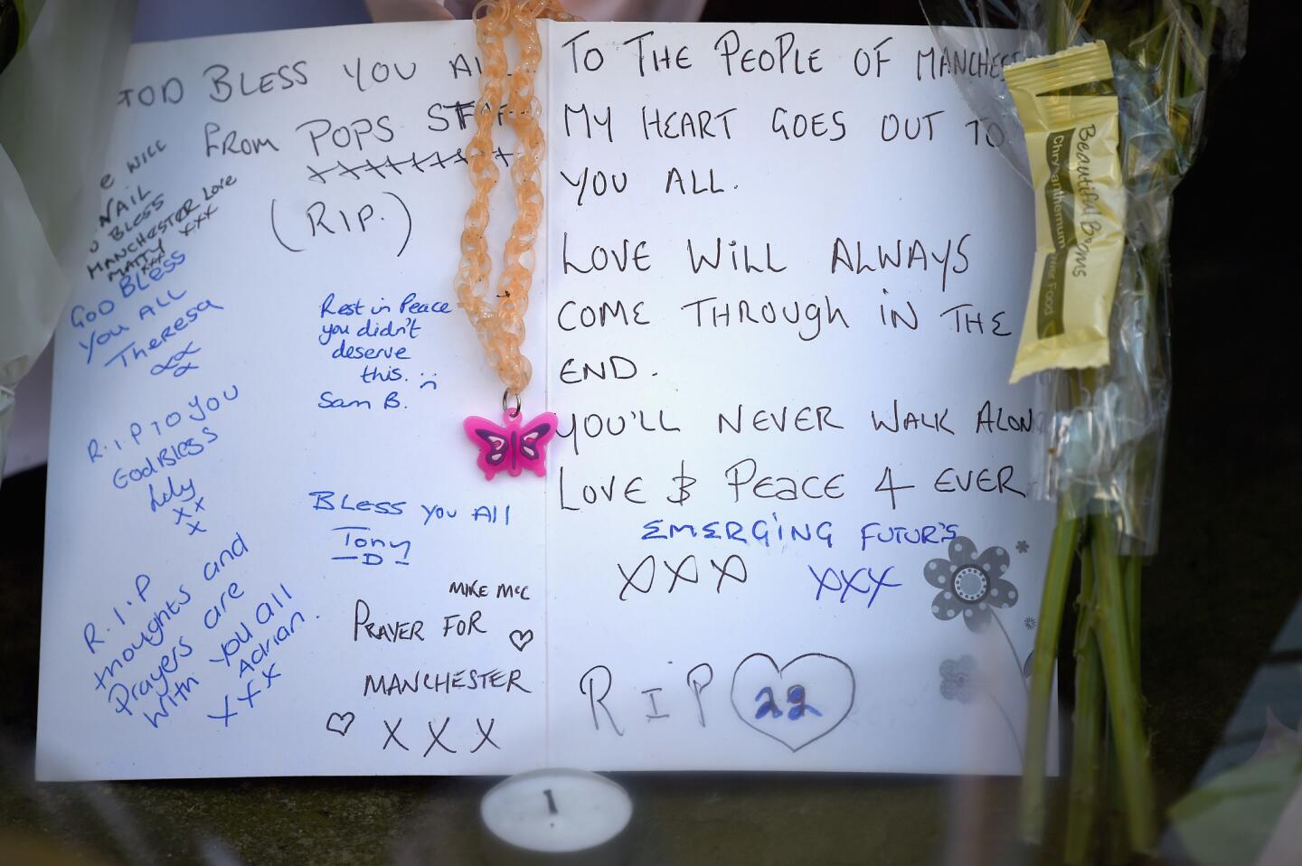 Messages are among the tributes left at a growing memorial in St. Ann's Ann Square in Manchester, England.