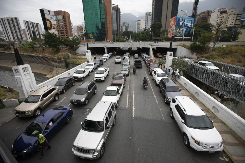 Vehicles line up near a gas station to fill their tanks, in Caracas, Venezuela, Friday, May 29, 2020. Venezuela boasts the world's largest underground oil reserves, but it has been forced to buy fuel from Iran to bridge deep shortages, unable to pump crude from the ground and turn it into gasoline. (AP Photo/Ariana Cubillos)