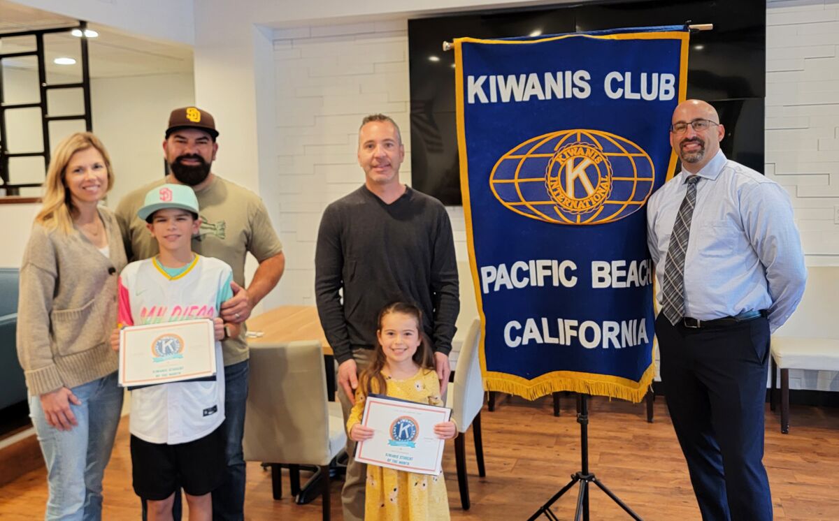 Beckett Phelps with his parents; Melissa Cohen with her father; and PB Kiwanis Club President Tony Bayona.