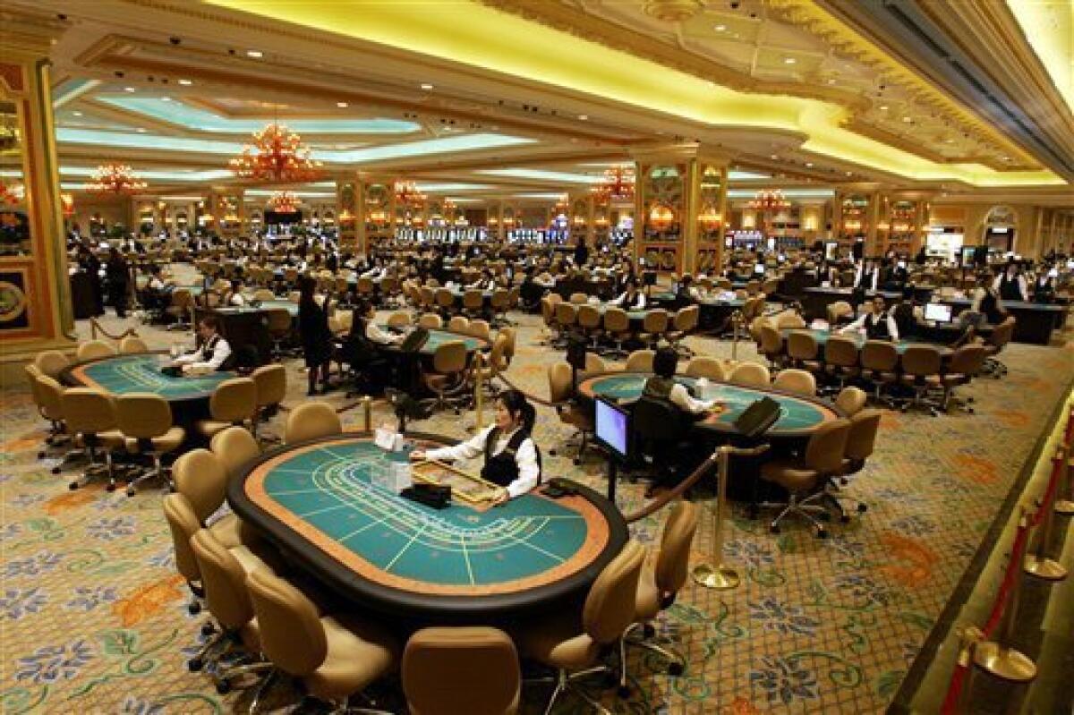 FILE - In th is Aug. 28, 2007 file photo, gambling tables are set inside the casino during the opening ceremony of the Venetian Macao Resort Hotel in Macau. U.S. billionaire Adelson's flagship Macau casino is suing two mainland Chinese high-rollers over gambling debts worth millions. The Venetian Macau took legal action in a Hong Kong court this week to recover about $4.5 million in the two separate cases. (AP Photo/Kin Cheung, File)