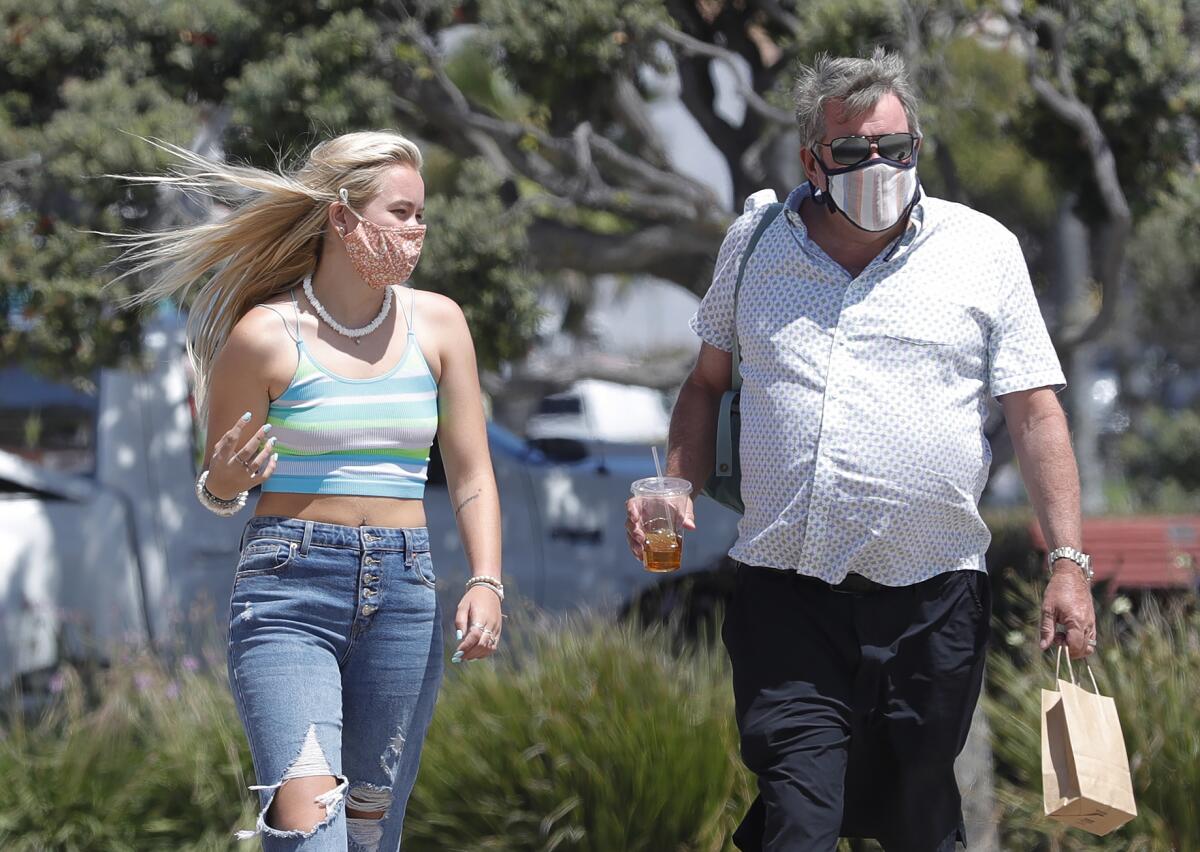 Megan Harris, left, and her father, Ray, walk the boardwalk in Laguna Beach on Thursday.