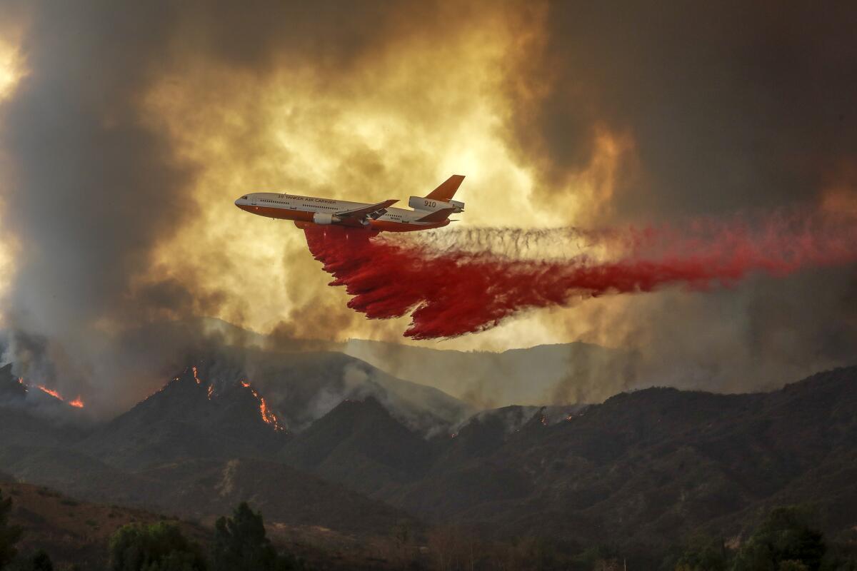 A DC-10 makes a fire retardant drop over Holy fire.