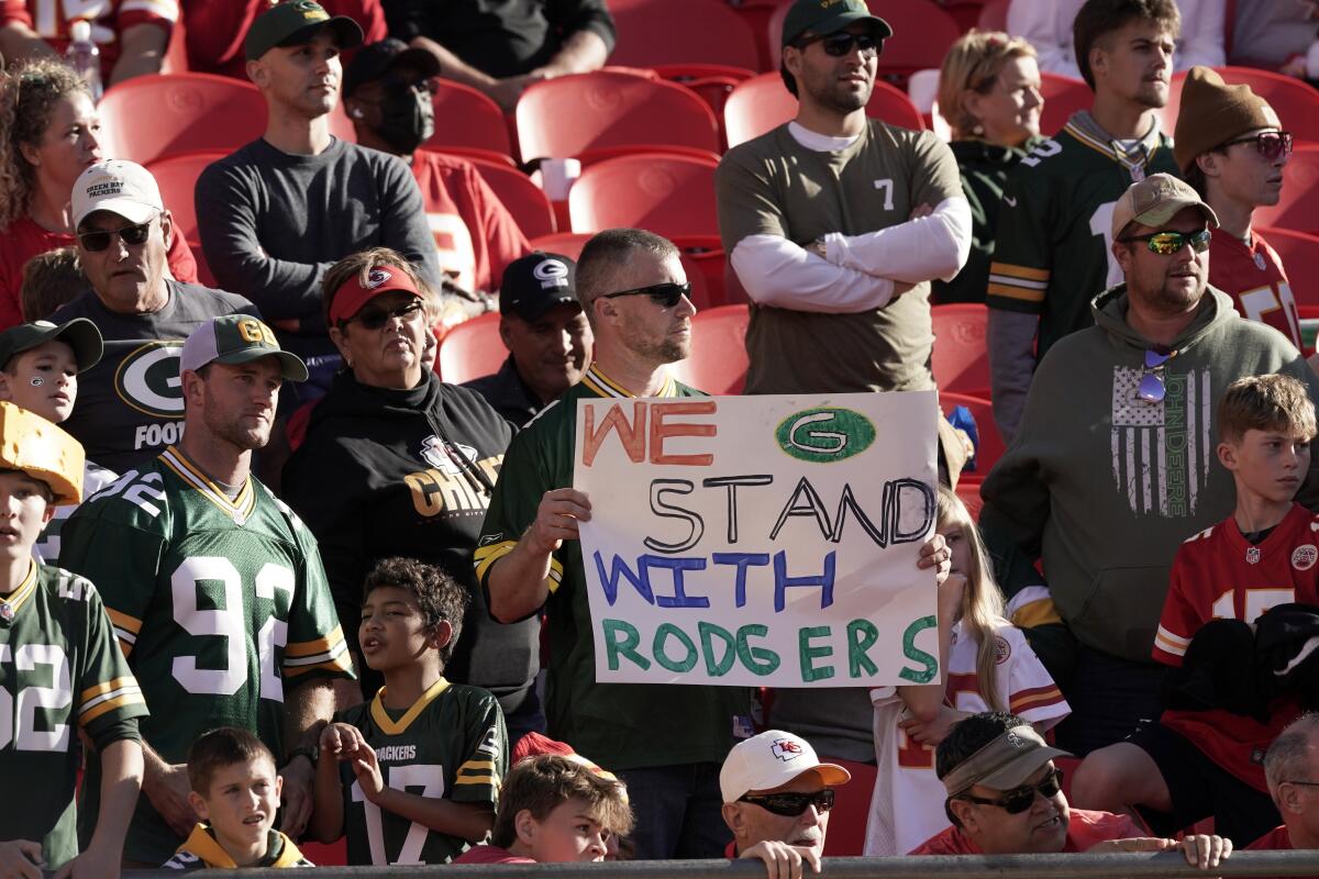 En foto del 7 de noviembre del 2021, un aficionado sostiene un mensaje en apoyo al quarterback de los Packers de Green Bay.