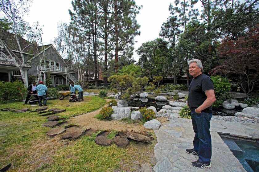 Arcadia Councilman Tom Beck watches a landscaping crew tear out the carefully tended landscaping surrounding his suburban house.