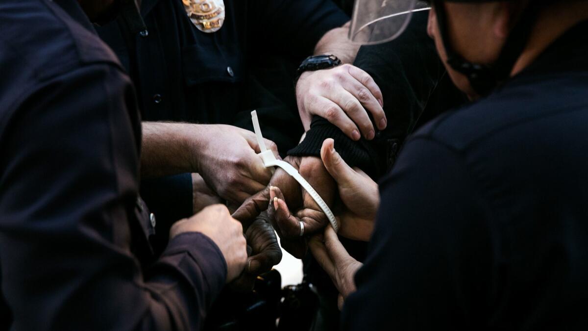 Los Angeles police officers place plastic handcuffs on a protester's hands during a demonstration on Dec. 13, 2014.