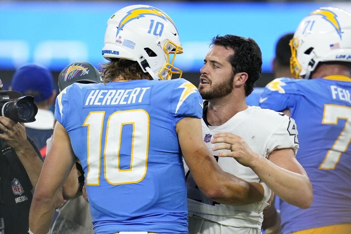Los Angeles Chargers quarterback Justin Herbert (10) talks with Las Vegas Raiders quarterback Derek Carr after the Chargers defeated the Raiders 28-14 in an NFL football game Monday, Oct. 4, 2021, in Inglewood, Calif. (AP Photo/Marcio Jose Sanchez)