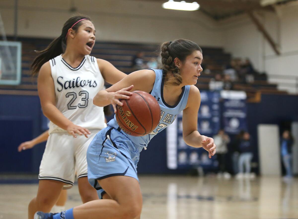 Corona del Mar's Trasara Alexander drives around Newport Harbor's Cydney Jover during the Battle of the Bay game on Thursday.