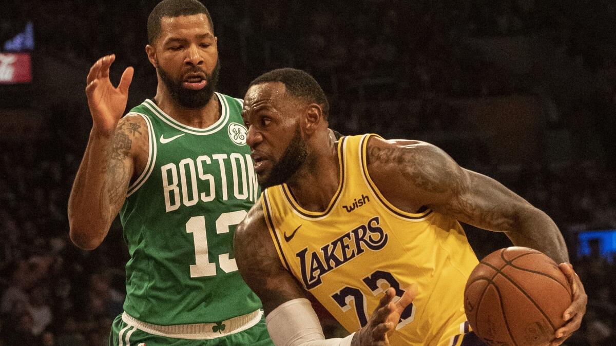 Lakers' LeBron James dribbles past Boston Celtics' Marcus Morris at Staples Center on Saturday.