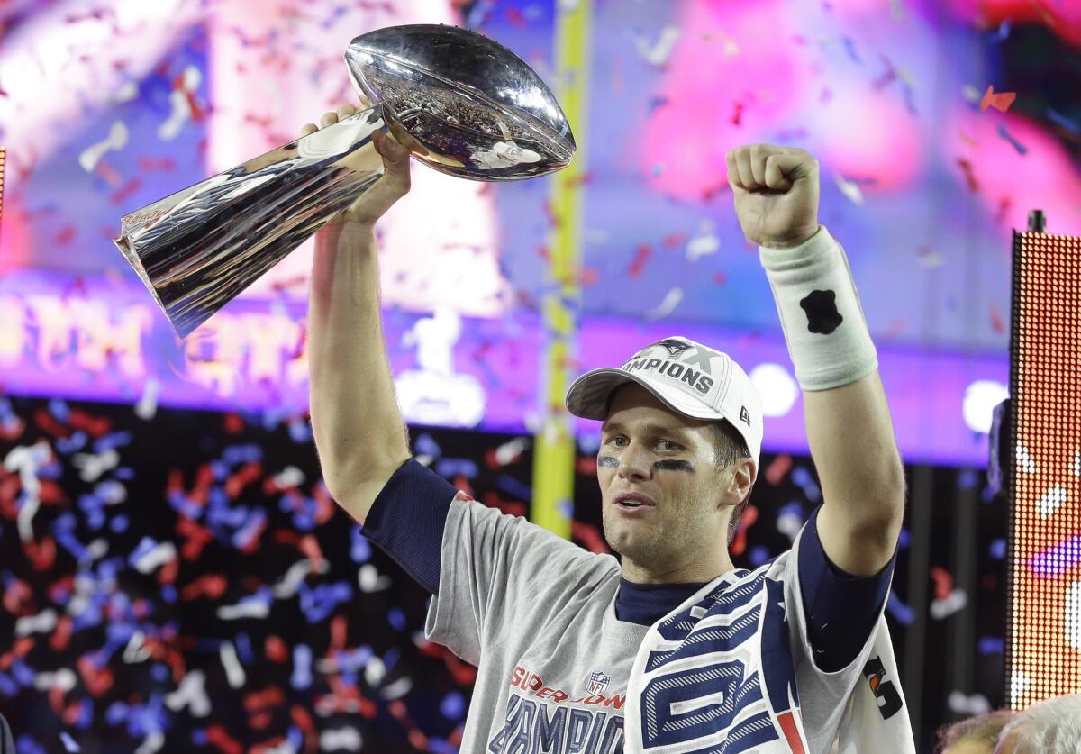 New England Patriots quarterback Tom Brady holds up the Vince Lombardi Trophy after winning Super Bowl XLIX.