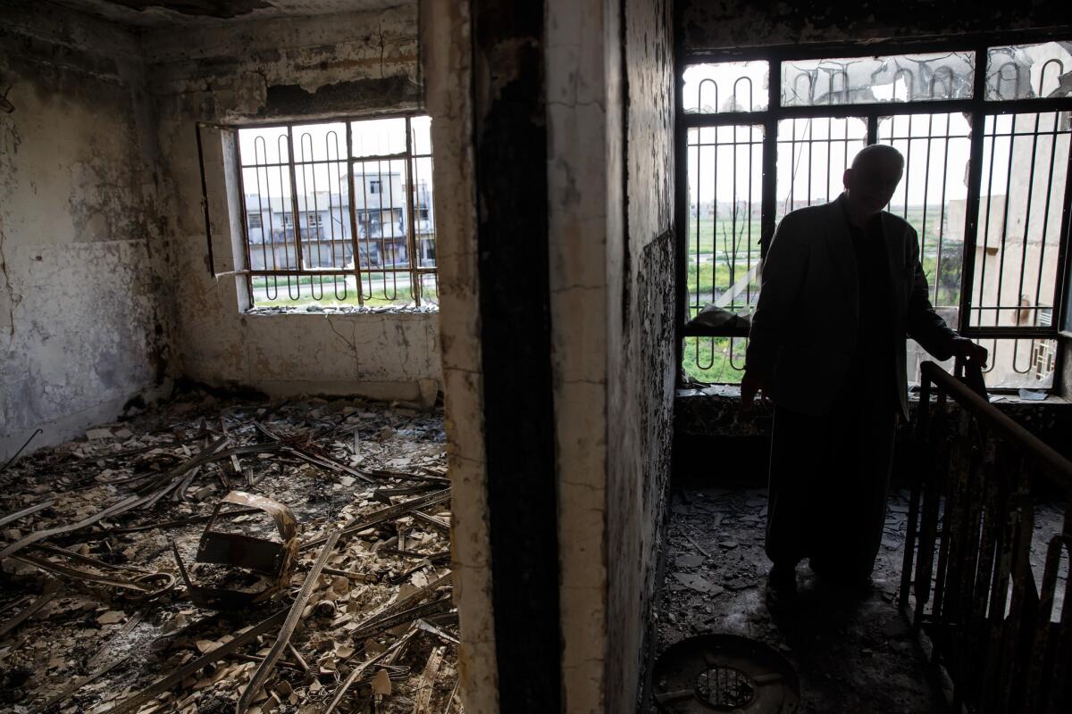 Tawfiq Abosh Jabu Sakar wanders through his home destroyed by Islamic State in Qaraqosh, Iraq. (Marcus Yam / Los Angeles Times)
