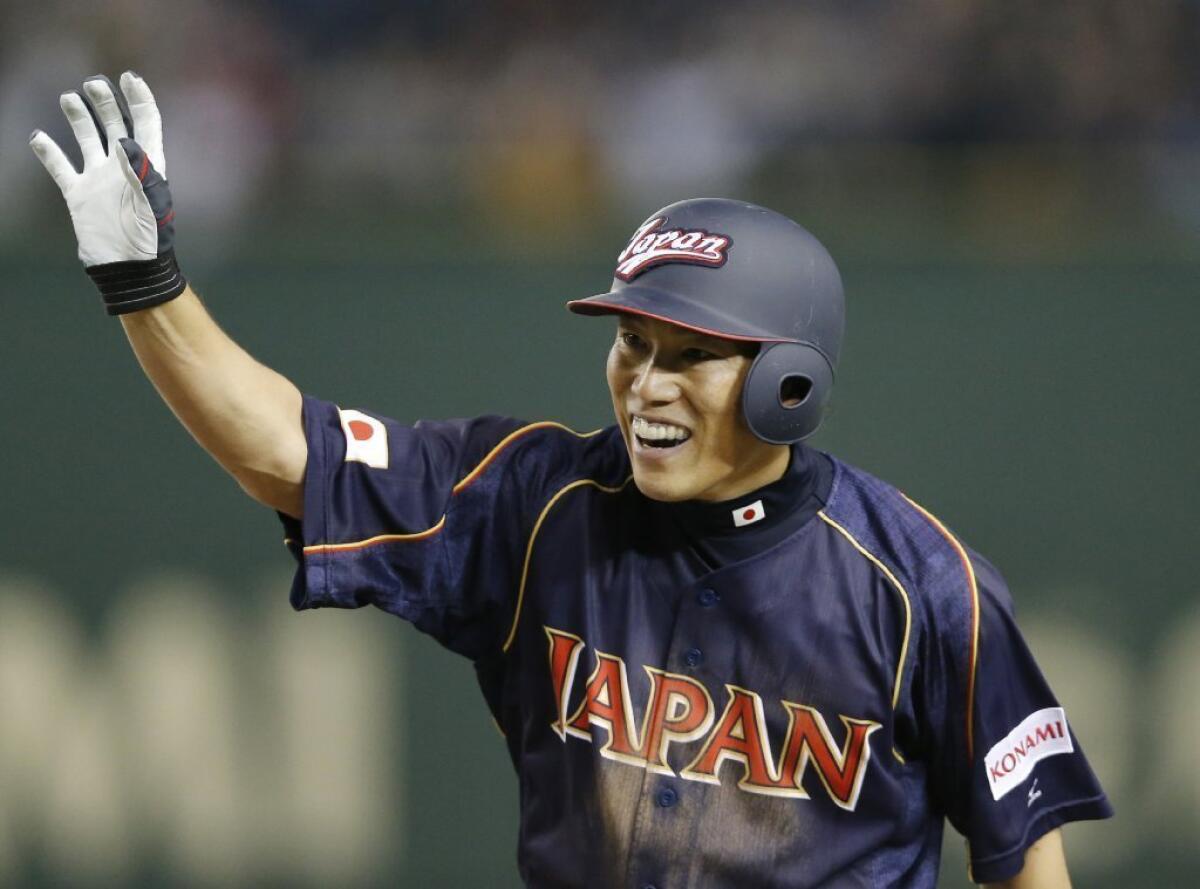 Hirokazu Ibata acknowledges the crowd's cheers after hitting a game-tying RBI single in the ninth inning of Japan's 4-3, 10-inning victory over Chinese Taipei on Friday in the World Baseball Classic.