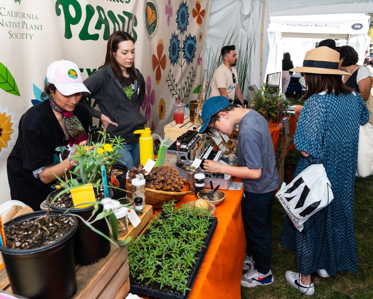 People visit the L.A. Times Plants booth at the 2023 Festival of Books.