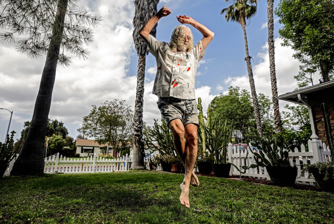 May 20: Concert superfan Howard Mordoh jumps in the air in a yard with a fence and trees