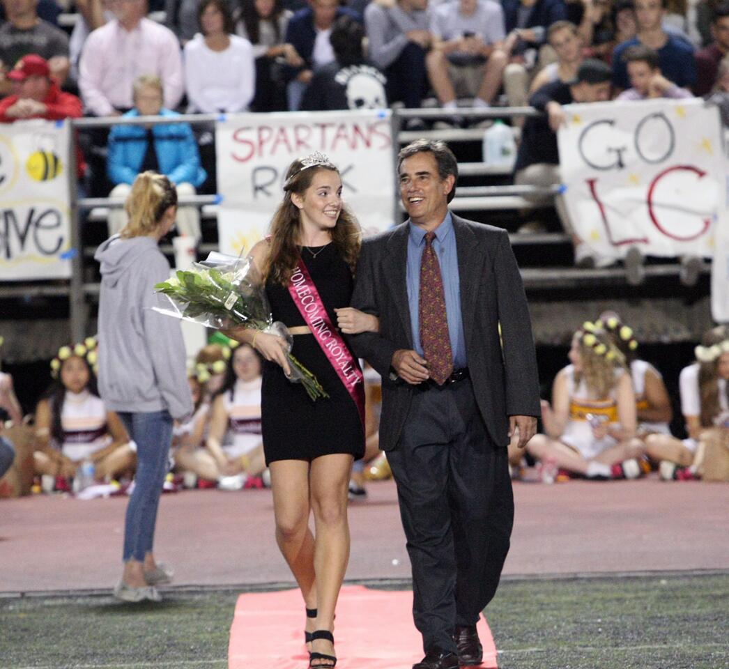 Homecoming court member Jesse Landesman is escorted by her father Jeff during halftime at the La Cañada High School football game on Friday, Oct. 16, 2015.