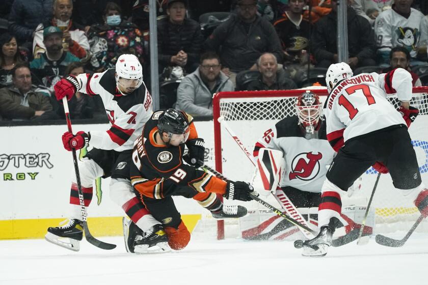 New Jersey Devils goaltender Jonathan Bernier (45) guards his net as Anaheim Ducks' Troy Terry (19) shoots under pressure by Devils' Yegor Sharangovich (17) and Jonas Siegenthaler (71) during the first period of an NHL hockey game Tuesday, Nov. 2, 2021, in Anaheim , Calif. (AP Photo/Jae C. Hong)