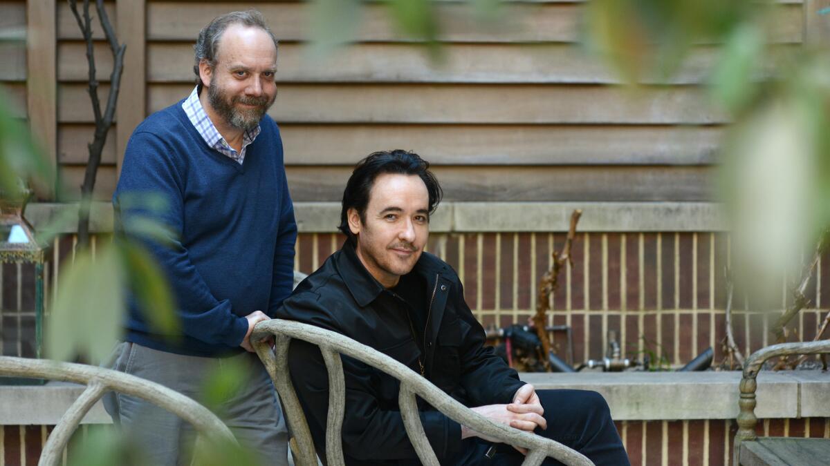 Actors Paul Giamatti and John Cusack, in black jacket, at the Crosby Street Hotel in Manhattan, NY.