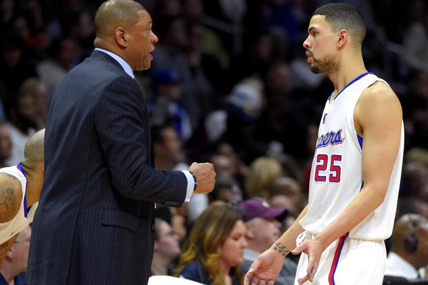 Clippers Coach Doc Rivers talks to his son, newly acquired guard Austin Rivers, as he leaves the court in the first half of their game against the Cavaliers.