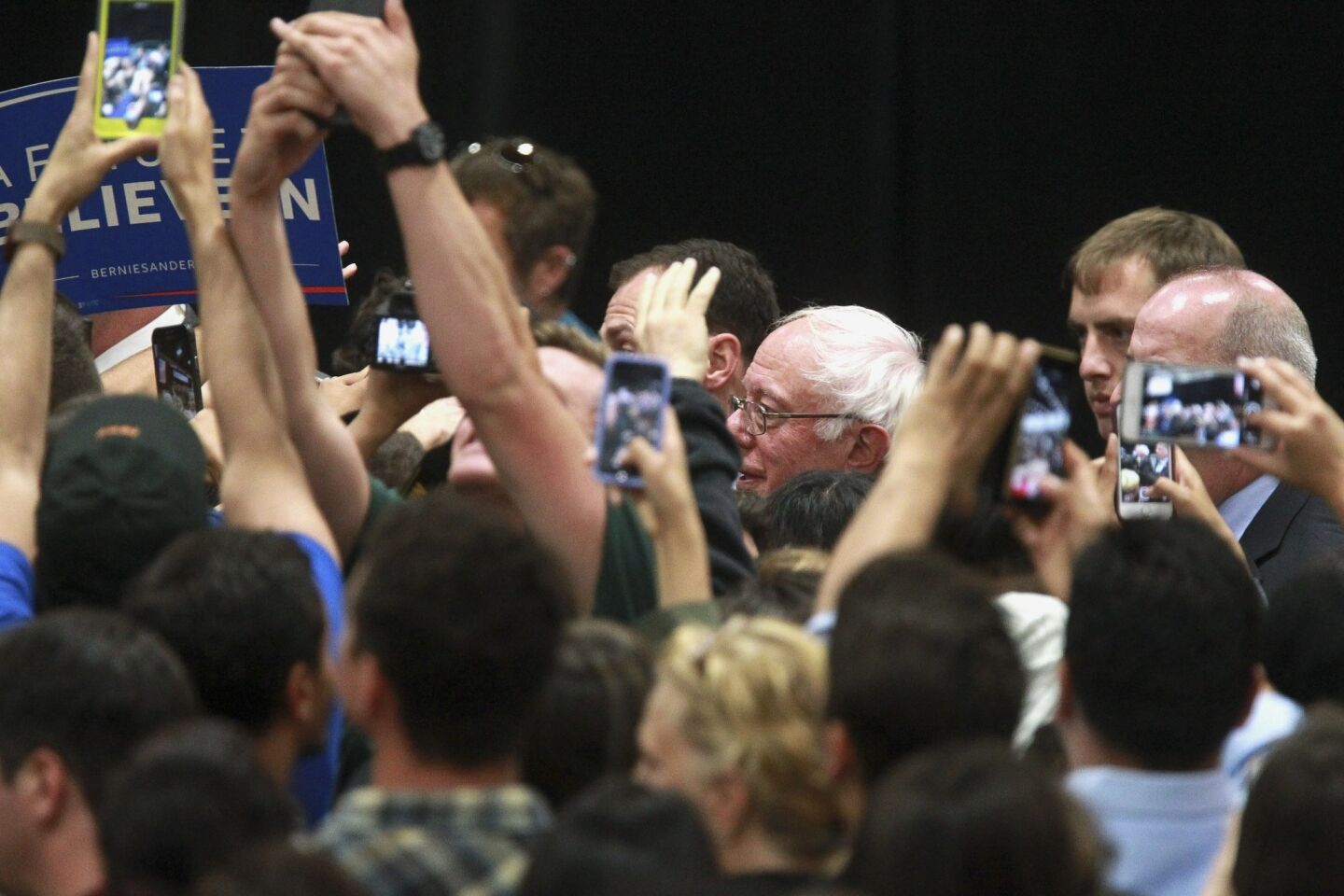 Democratic presidential candidate Bernie Sanders shakes hands with supporters as he exits after his speech.