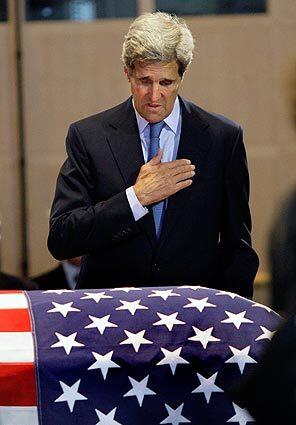 Sen. John F. Kerry (D-Mass.) pays his respects at Sen. Edward M. Kennedy's flag-draped coffin.