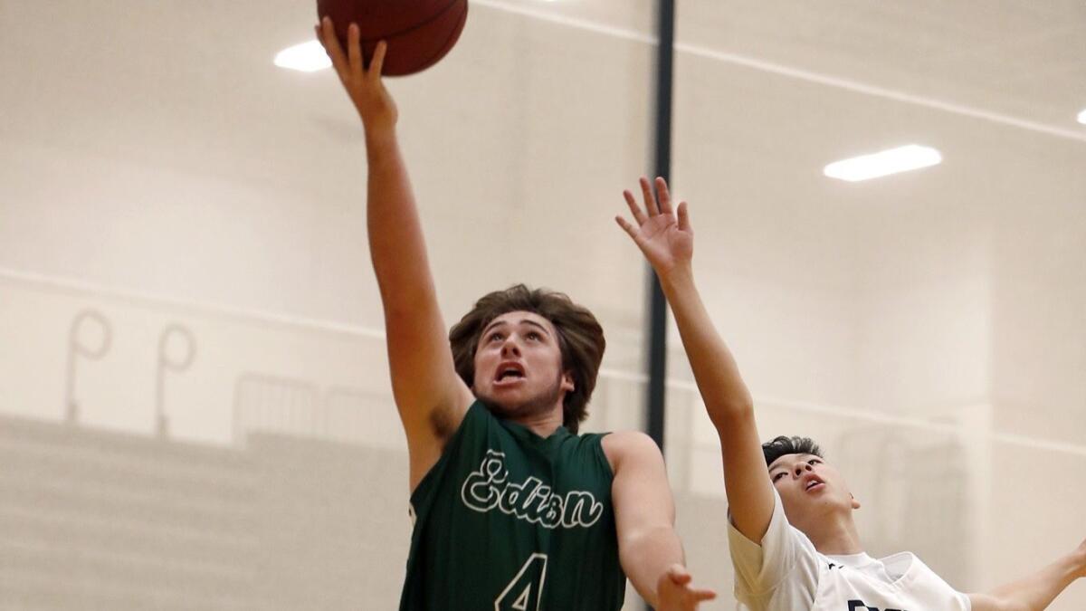 Edison High's Jack Horton (4) scores two of his game-high 19 points against Calvary Chapel's Chandler Kim (10) in the first half of the Grizzly Invitational pool-play game at Godinez High on Wednesday.