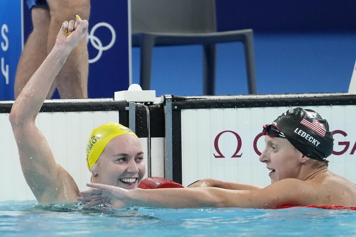Australian Ariarne Titmus celebrates after winning the women's 400-meter freestyle final as Katie Ledecky watches.