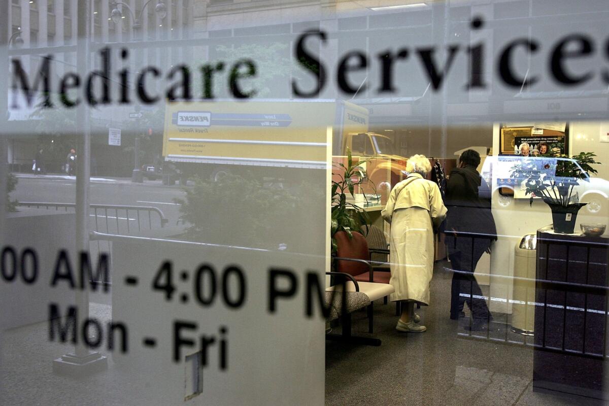 Two people walk inside a Medicare Services office in New York City in 2006.