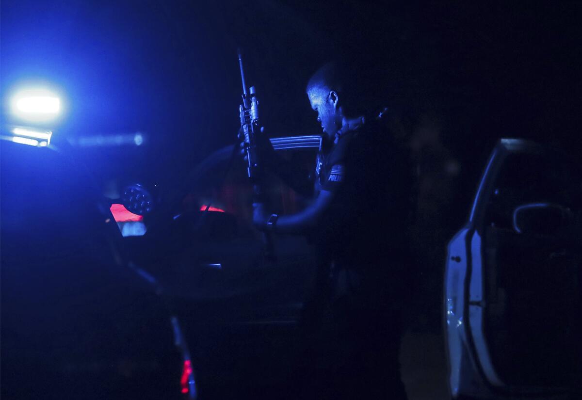 A Memphis police officer loads his gun in the dark at a crime scene 