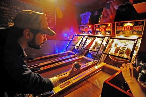 Eric Pavony, owner of the Full Circle Bar in Brooklyn, N.Y., rolls a game.