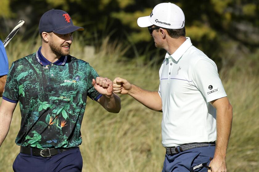 Justin Rose, right, is congratulated by playing partner Justin Timberlake after making a birdie on the fourth green at Spyglass Hill on Thursday.