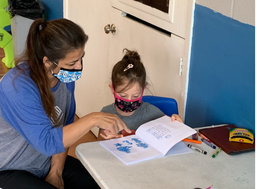 A Boys & Girls Clubs of San Dieguito staff member provides homework assistance to a young student.