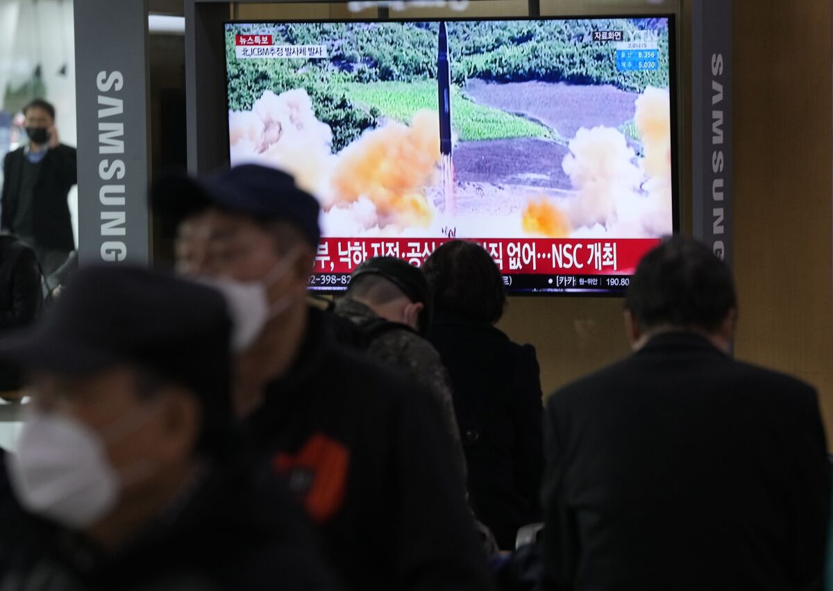 An outdoor TV monitor in Seoul shows a missile launch.