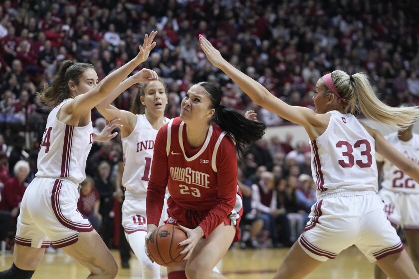 Ohio State's Rebeka Mikulasikova (23) goes to the basket against Indiana's Mackenzie Holmes (54) and Sydney Parrish (33) during the first half of an NCAA college basketball game Thursday, Jan. 26, 2023, in Bloomington, Ind. (AP Photo/Darron Cummings)