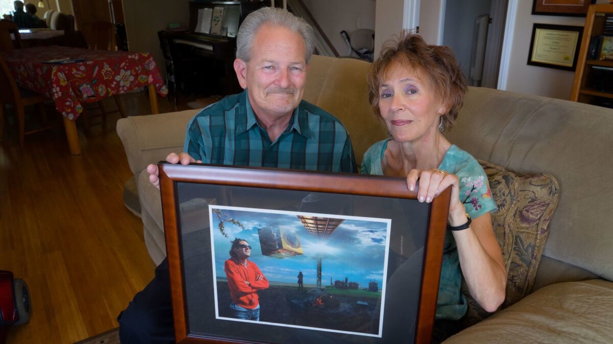 Rex and Connie Kennemer hold a photo of their 25-year-old son, Todd, at their home in Rancho Bernardo. The couple run a mental health support organization in memory of their son, who committed suicide in 2005.