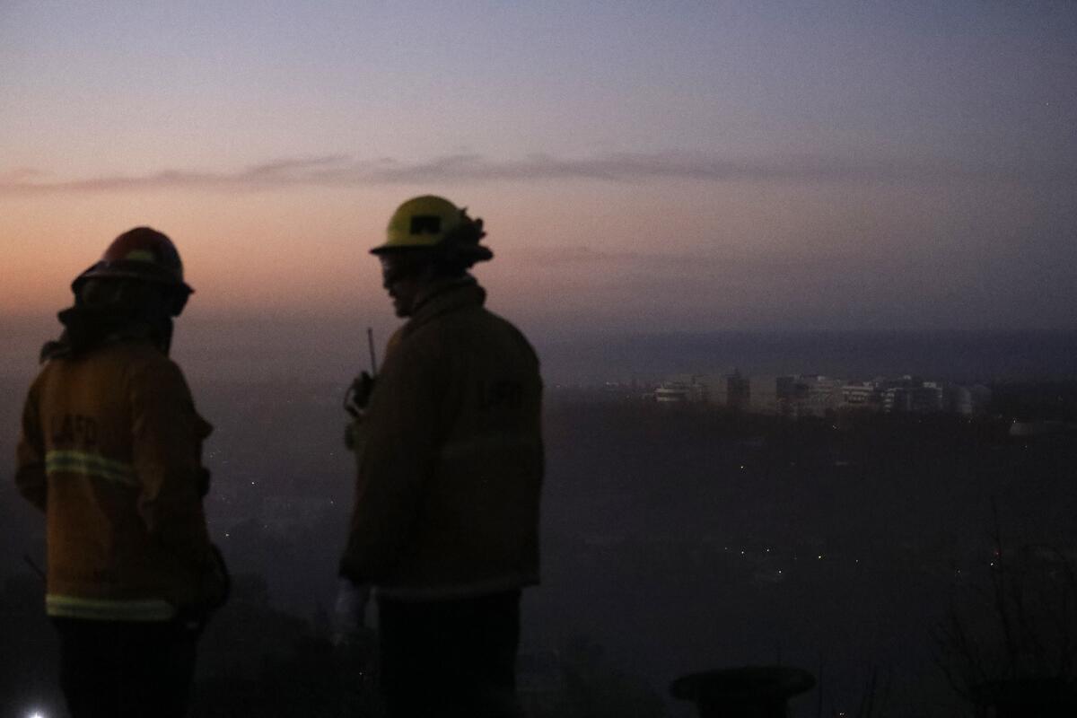 ptain Bob Williams, left, and firefighter Bobby D'Amico look for hot spots from the Skirball fire Thursday morning.