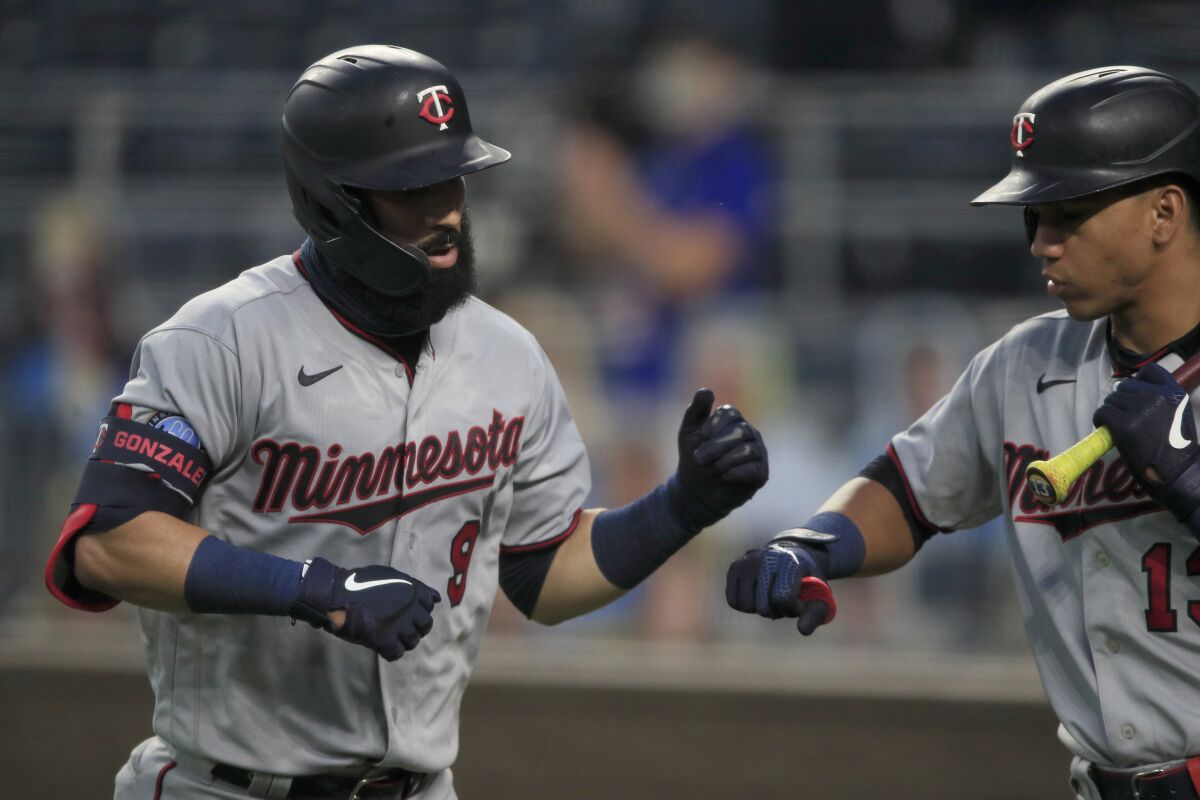 Minnesota Twins' Marwin Gonzalez (9) is congratulated by teammate Ehire Adrianza (13) after his solo home run during the fourth inning of a baseball game against the Kansas City Royals at Kauffman Stadium in Kansas City, Mo., Friday, Aug. 7, 2020. (AP Photo/Orlin Wagner)