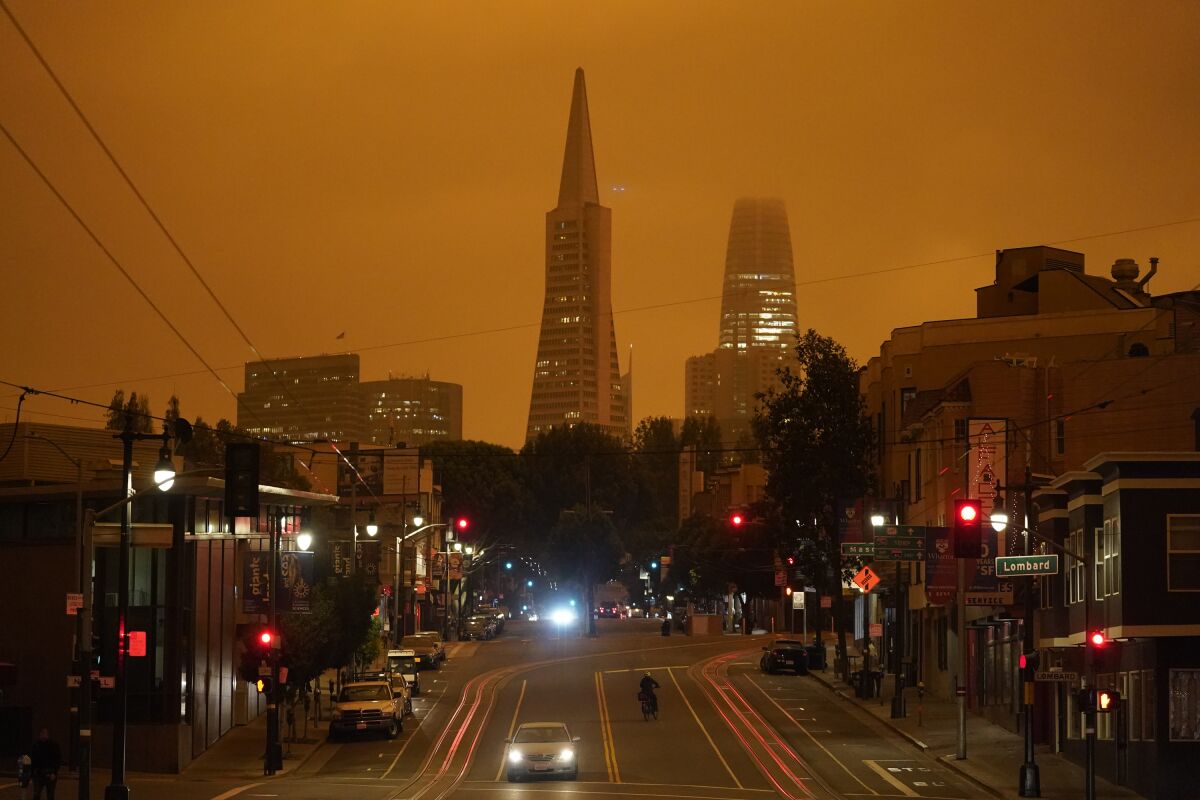 An orange smoky haze obscures the top of skyscrapers in San Francisco