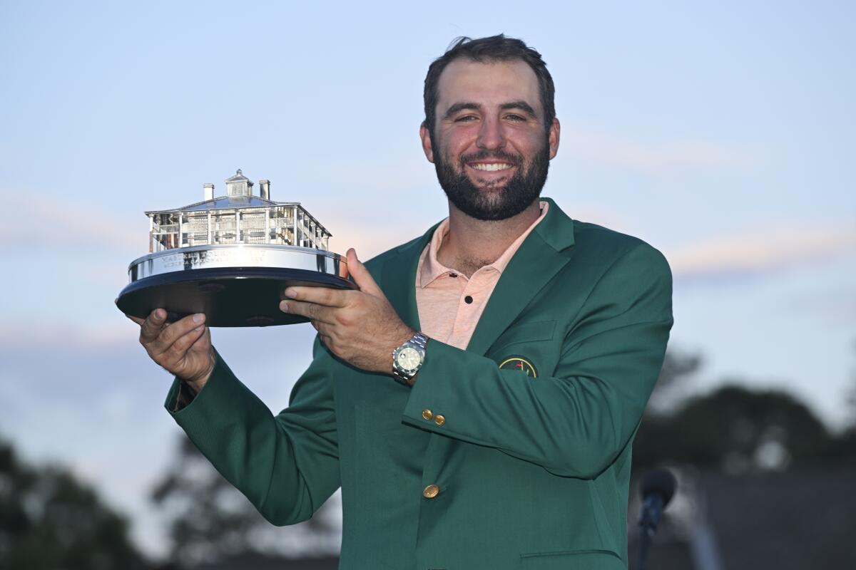 Scottie Scheffler poses with the winner's trophy after winning the Masters on Sunday.