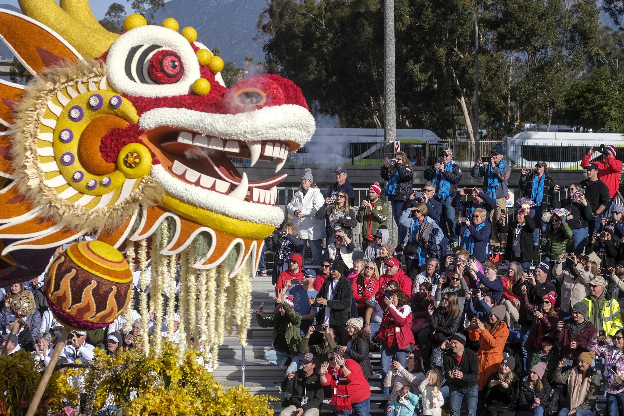 A large dragon head on a Rose Parade float.