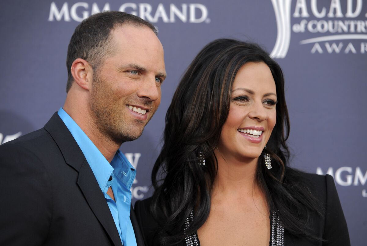 FILE - Former Alabama quarterback Jay Barker, left, and his wife country music singer Sara Evans arrive at the 46th annual Academy of Country Music Awards in Las Vegas on April 3, 2011. Barker was arrested Saturday, Jan. 15, 2022, on a felony domestic violence charge, Tennessee authorities said. (AP Photo/Chris Pizzello, File)