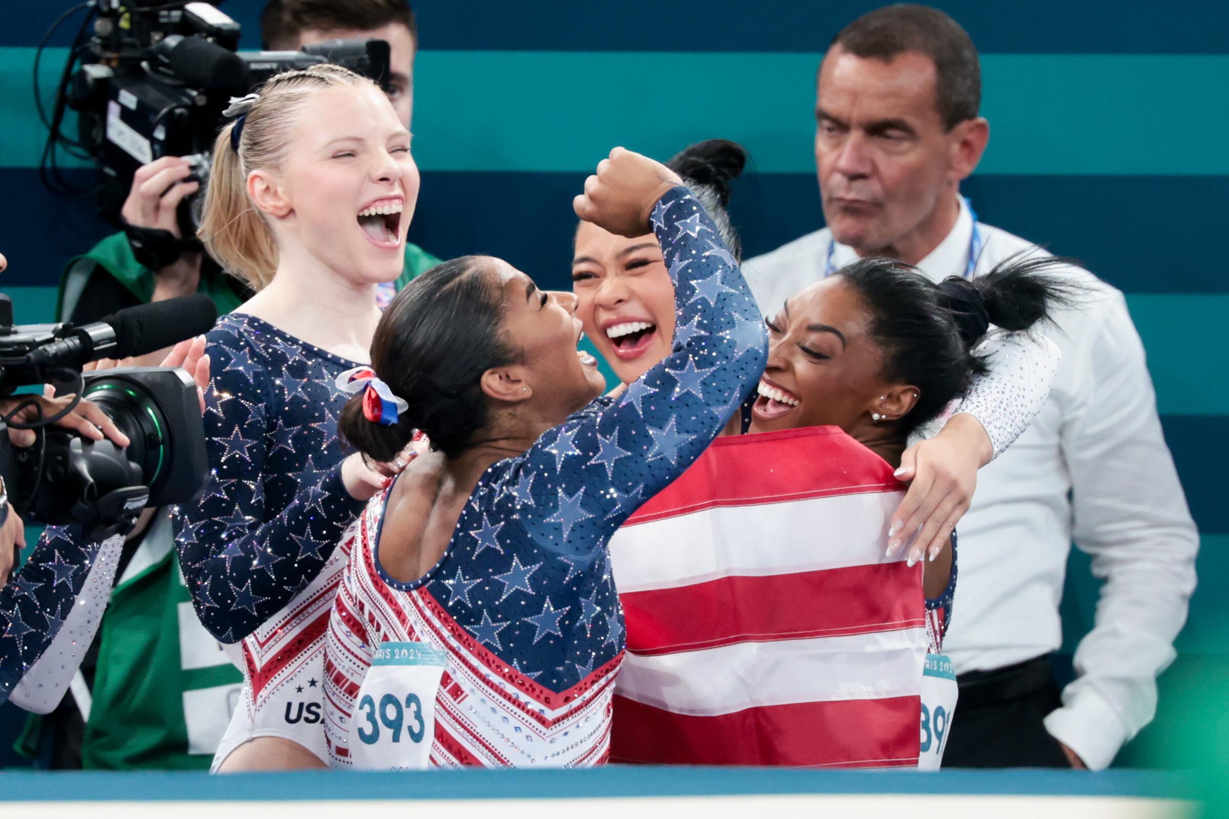 Team USA's Jade Carey, from left, Jordan Chiles, Suni Lee and Simone Biles celebrate after winning gold