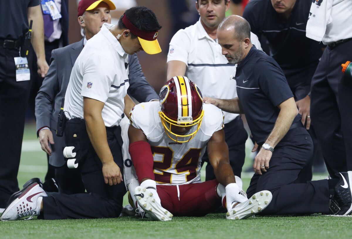 Washington Redskins cornerback Josh Norman is attended to by trainers against the Detroit Lions during a game in Detroit on Oct. 23, 2016. Norman left the game with a concussion.