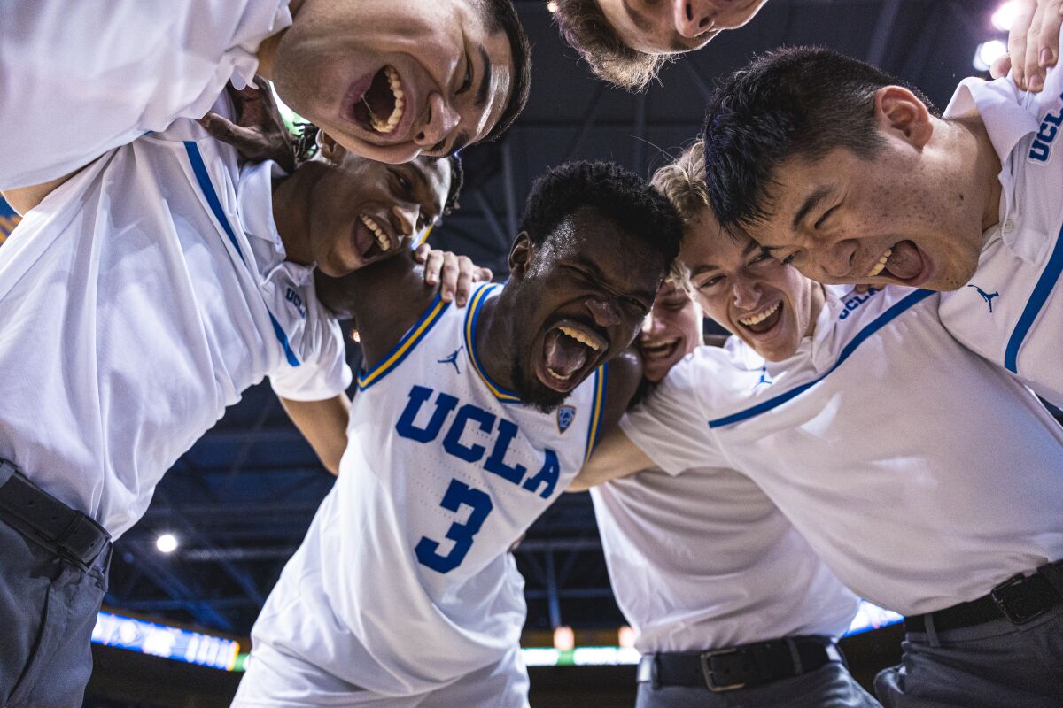 Adem Bona celebrates with UCLA’s student managers after a win over Colorado on Jan. 14.