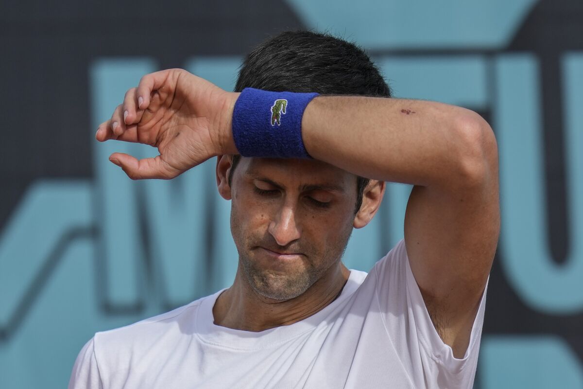 FILE - Novak Djokovic, of Serbia, wipes the sweat off during a training session at the Mutua Madrid Open tennis tournament in Madrid, Spain, on April 30, 2022. Djokovic withdrew from the upcoming hard-court tournament in Montreal on Thursday, AUg. 4, 2022, because he is not vaccinated against COVID-19 and is therefore not allowed to enter Canada. (AP Photo/Manu Fernandez, File)