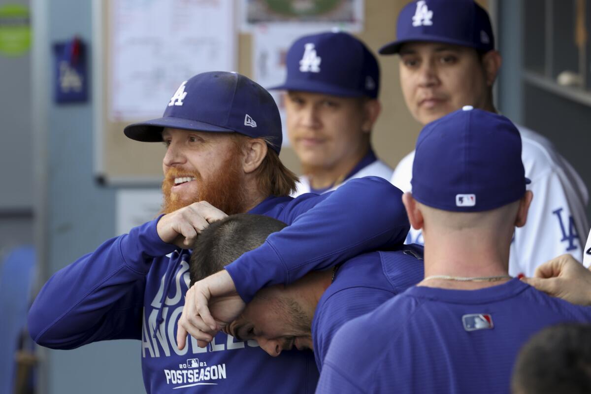 Dodgers third baseman Justin Turner, left, goofs off in the dugout during the first inning.