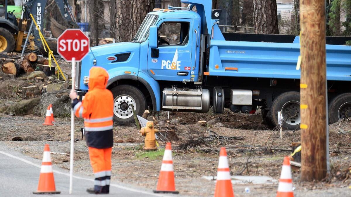 Pacific Gas & Electric crews work to restore utility services in Paradise, Calif., on Feb. 1. PG&E, facing billions of dollars in potential liabilities over its role in a series of deadly wildfires, filed for bankruptcy protection Jan. 29.