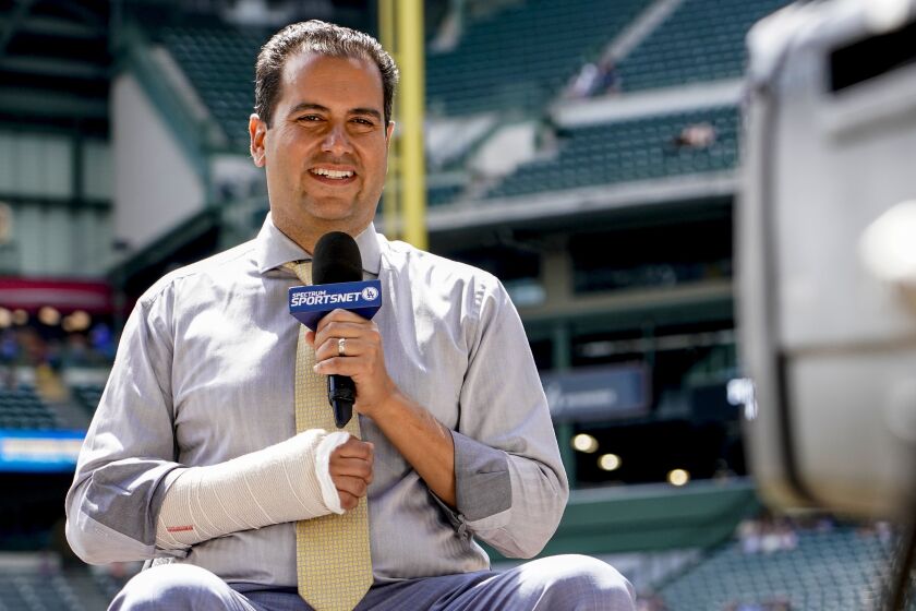 Los Angeles Dodgers television reporter David Vassegh works on a pregame broadcast.