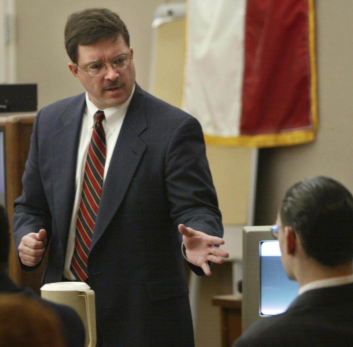Prosecution attorney Rick Jackson, left, makes his closing arguments in front of Donald Newbury during Newbury's capital murder trial on Friday, Jan. 18, 2002 in Dallas. The former Dallas County prosecutor has surrendered his law license after the State Bar of Texas said he withheld evidence that led to the wrongful convictions of two men who spent 14 years in prison in the fatal stabbing of a pastor. (Andy Scott/The Dallas Morning News via AP, file)