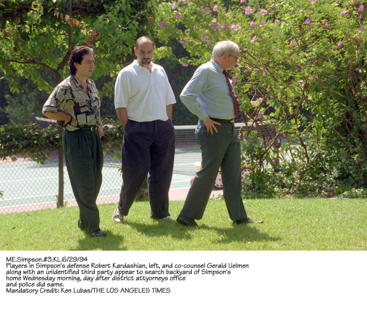 Robert Kardashian left, with attorney Gerald Uelman, right, and an unidentified third party in O.J. Simpson's back yard the day after police and officials from the D.A.'s office searched it.